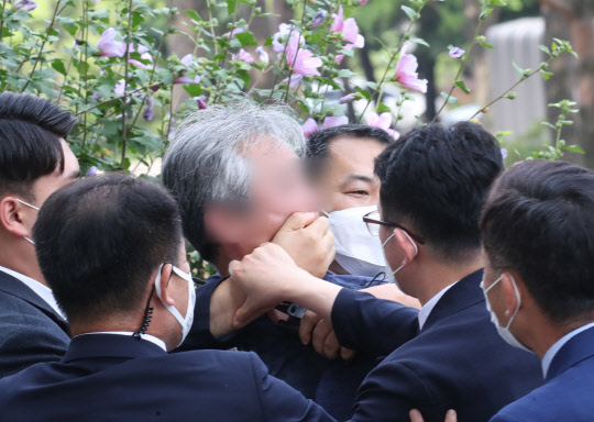 대통령 경호원들이 16일 오후 서울 여의도 국회에서 열린 제21대 국회 개원식에 참석한 문재인 대통령을 향해 신발을 던지고 소리를 지르는 시민의 입을 막고 있다.  [연합뉴스]